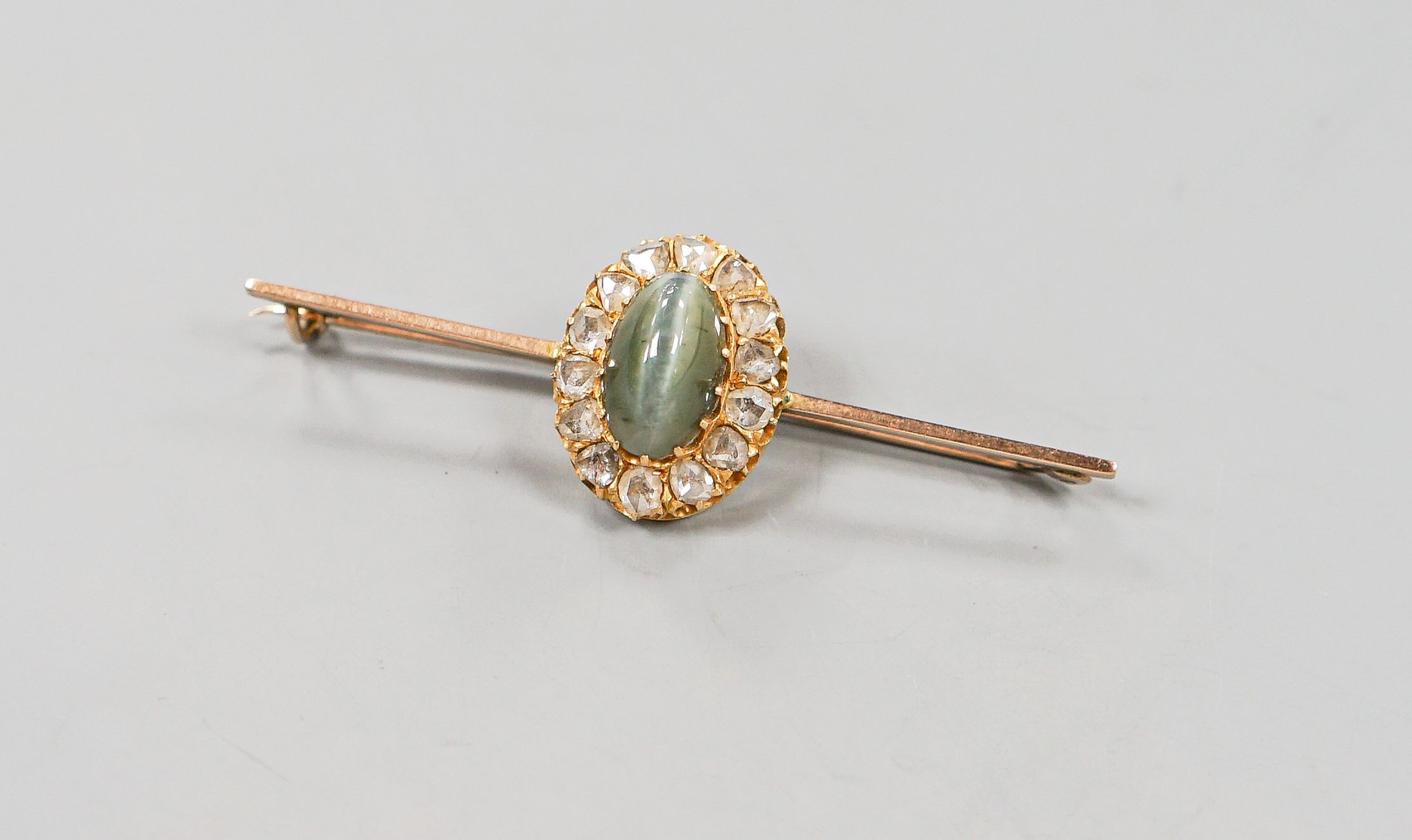 A yellow metal cat's eye chrysoberyl and rose cut diamond set bar brooch, 62mm, gross weight 6 grams.